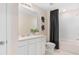 Modern bathroom with sleek white cabinets, tiled shower-tub, and contemporary fixtures at 415 Meadowland Pt, Oviedo, FL 32765