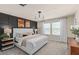 Modern main bedroom with an accent wall, plush carpet, neutral bedding, and natural light from two windows at 431 Meadowland Pt, Oviedo, FL 32765