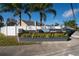 Beautiful community entrance sign surrounded by a white fence and palm trees against a beautiful blue sky at 4523 Saddle Creek Pl, Orlando, FL 32829