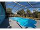 Private in-ground pool surrounded by a screened enclosure and backyard greenery at 4523 Saddle Creek Pl, Orlando, FL 32829