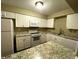 Bright kitchen features white cabinets, granite countertops, and updated stainless steel appliances at 516 Orange Dr # 17, Altamonte Springs, FL 32701