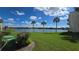 Scenic view of a serene lake with lush green lawn and palm trees at 516 Orange Dr # 17, Altamonte Springs, FL 32701