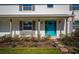 Charming home entrance featuring a vibrant blue door, stone accents, manicured landscaping, and decorative outdoor lighting at 533 Little Wekiva Rd, Altamonte Springs, FL 32714