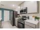 Modern kitchen featuring stainless steel appliances, gray cabinets, and light countertops at 560 Newton Rd, Port Orange, FL 32127