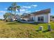 A view of the backyard with a screened lanai, lush lawn and beautiful palm trees at 5795 Parkview Lake Dr, Orlando, FL 32821