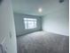 An empty bedroom featuring neutral carpet, a window providing natural light, and freshly painted walls at 5961 Vision Rd, St Cloud, FL 34771