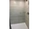 Shower showcasing large, light-colored tiles, a glass corner shelf, and a modern shower head at 5961 Vision Rd, St Cloud, FL 34771