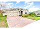 Attractive single-Gathering home with a brick driveway, two-car garage and manicured lawn at 6097 Monterey Cypress Trl, Sanford, FL 32773