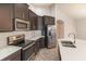 Modern kitchen with stainless steel appliances, dark cabinetry, and white countertops at 6097 Monterey Cypress Trl, Sanford, FL 32773