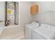 Bright laundry room featuring a washer, dryer, and built-in shelving at 6097 Monterey Cypress Trl, Sanford, FL 32773