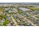 Aerial view of a neighborhood showcasing tree-lined streets, residences, and nearby commercial areas at 636 Bainbridge Loop, Winter Garden, FL 34787