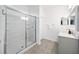 Modern bathroom with a glass-enclosed shower, white vanity, and gray tiled floors at 636 Bainbridge Loop, Winter Garden, FL 34787