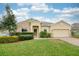 Charming single-story home with manicured lawn, stone accents, and a welcoming front entrance at 636 Bainbridge Loop, Winter Garden, FL 34787