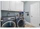 Practical laundry room featuring a washer and dryer, white cabinets, and tiled floor at 636 Bainbridge Loop, Winter Garden, FL 34787