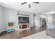 Open-concept living room showcasing wood floors, a ceiling fan, and a view into the modern kitchen at 636 Bainbridge Loop, Winter Garden, FL 34787