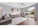 Cozy living room featuring a plush sofa, ceiling fan, and sliding glass doors to the backyard at 636 Bainbridge Loop, Winter Garden, FL 34787