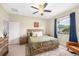 Comfortable bedroom features a cozy bed, ceiling fan, and natural light from the window at 636 Bainbridge Loop, Winter Garden, FL 34787