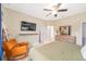 Spacious bedroom with a ceiling fan, chair, and a glimpse into the ensuite bathroom at 636 Bainbridge Loop, Winter Garden, FL 34787