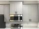 Modern kitchen with stainless steel microwave, ample gray cabinets, and sleek hardware at 6889 Se 23 Ave, Ocala, FL 34480