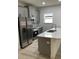 Close up of the kitchen featuring gray cabinetry, stainless steel appliances and a large sink at 6889 Se 23 Ave, Ocala, FL 34480