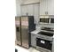 Well-equipped kitchen featuring stainless steel refrigerator, stove, and microwave with gray cabinetry at 6889 Se 23 Ave, Ocala, FL 34480