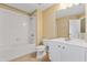 Well-lit bathroom featuring a shower-tub combo and a vanity with white cabinets at 6912 Hochad Dr, Orlando, FL 32819