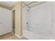 A bathtub with a shower and white tile surround, and a view into the doorway at 6912 Hochad Dr, Orlando, FL 32819