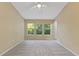 Sunlit bedroom featuring neutral carpet, three large windows, and a ceiling fan at 6912 Hochad Dr, Orlando, FL 32819