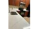 Close up of quartz countertops, stainless faucet, black appliances and cherry cabinets in a kitchen at 6912 Hochad Dr, Orlando, FL 32819