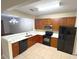 Well-lit kitchen featuring cherry cabinets, black appliances, and an open layout at 6912 Hochad Dr, Orlando, FL 32819