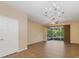Bright living room featuring chandelier, wood-style tile flooring and sliding doors to the screened patio at 6912 Hochad Dr, Orlando, FL 32819