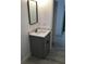 Modern bathroom vanity with a black framed mirror, grey cabinet, white sink, and faucet at 6915 Se 23 Ave, Ocala, FL 34480