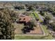 A birds eye view of a spacious home with a pool, patio, fenced yard, and mature trees at 1031 Kings Hwy, Kissimmee, FL 34744