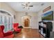 Comfortable living room with hardwood floors, red chairs, and a TV with entertainment center at 1031 Kings Hwy, Kissimmee, FL 34744