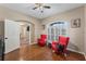 Cozy living room featuring hardwood floors, red chairs, and natural light from window with shutters at 1031 Kings Hwy, Kissimmee, FL 34744