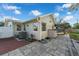 A backyard featuring a neutral-toned house, a tiled patio, a storage shed, and a screened-in pool area at 1232 Corbett Ln, Orlando, FL 32806