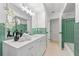 Bathroom featuring double vanity, with large mirrors, and green tile at 1232 Corbett Ln, Orlando, FL 32806