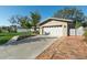 Exterior view of a well-manicured home with a white garage door and a brick-lined driveway at 1232 Corbett Ln, Orlando, FL 32806