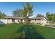 Charming single-story home with a manicured lawn, flower beds, and an American flag at 1232 Corbett Ln, Orlando, FL 32806