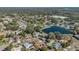 Serene aerial view of a neighborhood with a scenic pond and houses with private pools at 1320 Corte Nueva, Winter Springs, FL 32708