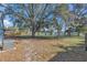 Large, shady backyard featuring a beautiful tree and a view of the lake at 1320 Corte Nueva, Winter Springs, FL 32708