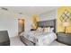 Bedroom with grey headboard, yellow accent wall, and a connected walk in closet at 1344 Hanoverian Dr, Lake Alfred, FL 33850