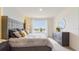 Bedroom with a large window view, gray headboard, gray dresser, and carpet at 1344 Hanoverian Dr, Lake Alfred, FL 33850