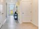 Bright hallway featuring neutral tile flooring, natural lighting, and decorative art at 1344 Hanoverian Dr, Lake Alfred, FL 33850