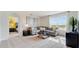 Cozy living room showcasing a gray sectional sofa and bright sunlight streaming through a large window at 1344 Hanoverian Dr, Lake Alfred, FL 33850