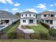 A home's manicured backyard features a stone patio, lush grass, and a charming garden, all enclosed by a sleek black fence at 16112 Vetta Dr, Montverde, FL 34756