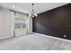 A spacious bedroom with a contemporary chandelier, neutral walls and plush gray carpet at 16112 Vetta Dr, Montverde, FL 34756