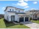 Charming two-story home with a stone facade, dark garage doors, and well-kept landscaping at 16112 Vetta Dr, Montverde, FL 34756