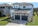 Two-story home showcasing a stone facade, gray garage doors and a well-manicured lawn at 16112 Vetta Dr, Montverde, FL 34756