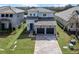 Two-story home with stone accents, dark garage doors, and a charming paver driveway at 16112 Vetta Dr, Montverde, FL 34756